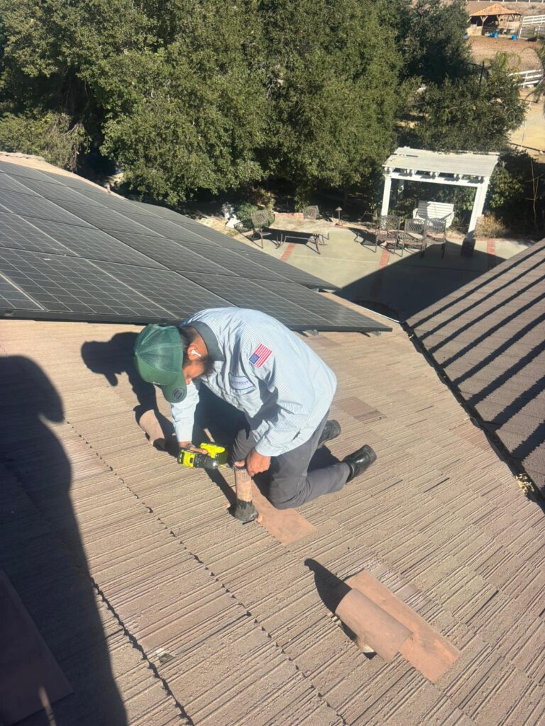 Technician reinforcing rooftop entry points to block pests using a drill
